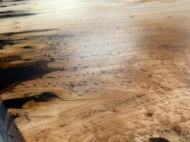 Close view of the figured willow grain and the black filled void